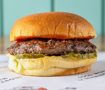 Yella’s hamburger with pickles, ketchup on a potato roll