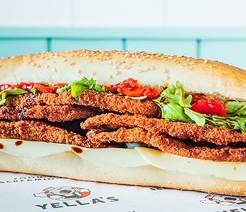 Eggplant Milanese deli sandwich with Crispy fried eggplant, provolone cheese, arugula, roasted red peppers, balsamic glaze on a seeded Italian hero.