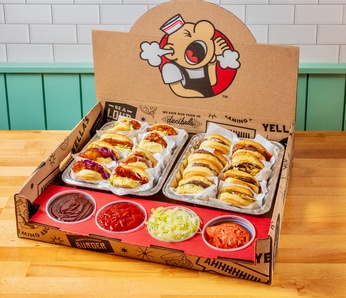 large catering box of hamburgers and sandwiches with ramekins of toppings