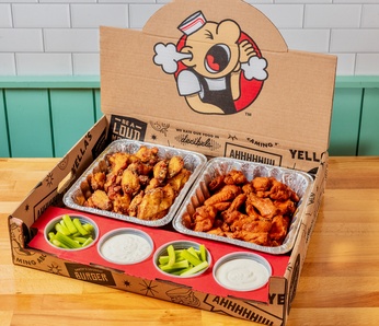 box of chicken wings and tenders with ramekins of dipping sauce for catering